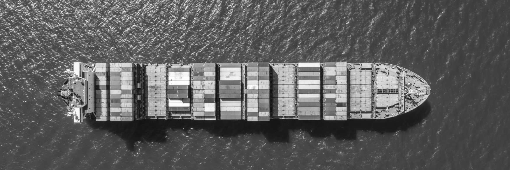 A loaded container ship at sea, seen from above